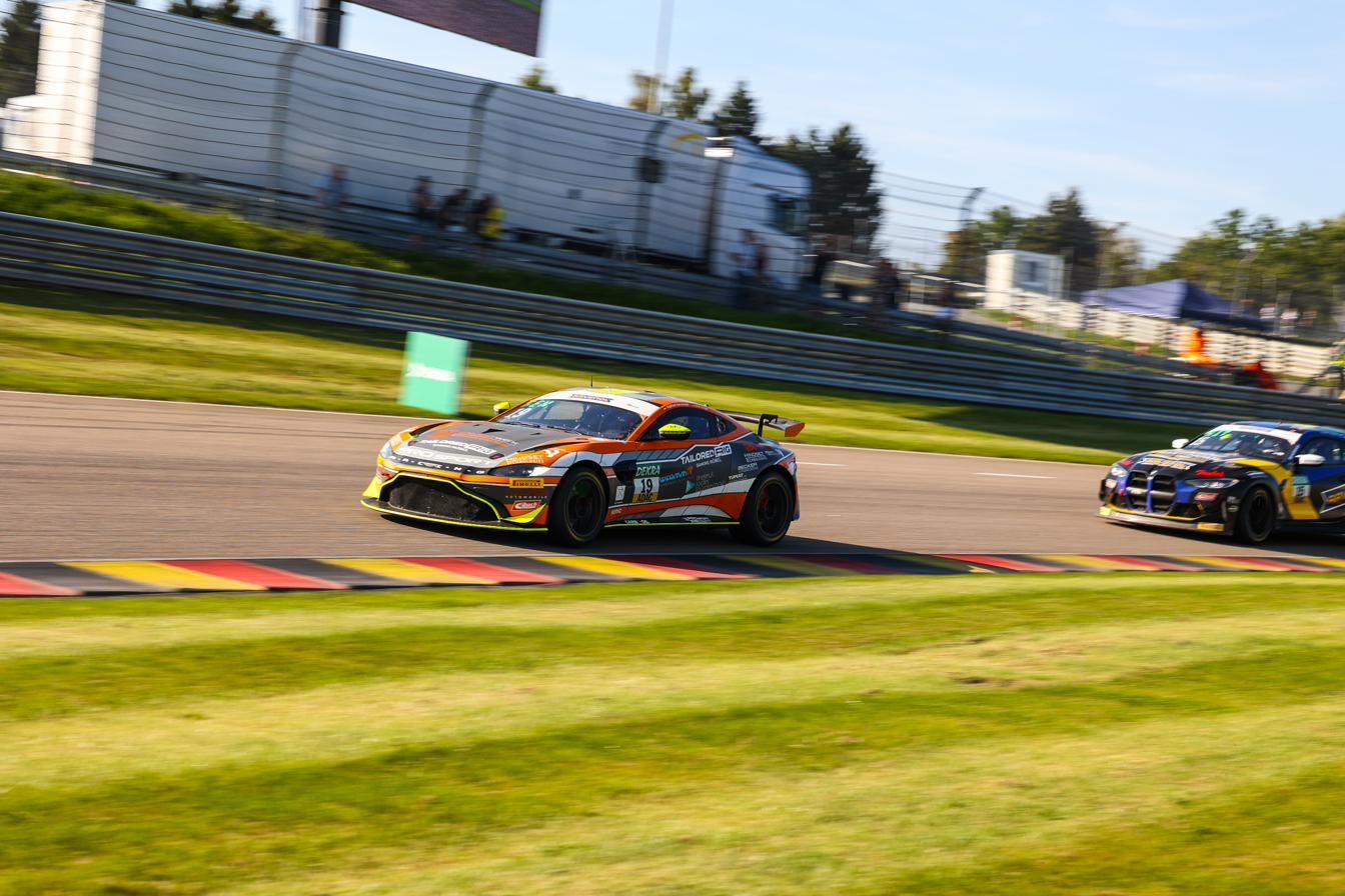 The number 19 Aston Martin Vantage GT4 on track ahead of a rival